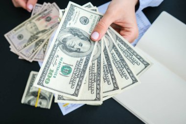 İş kadını, Amerikan dolarlarını sergiliyor. Yakın plan. Gelir ve İş Konsepti. Satış, rüşvet, yolsuzluk konsepti. El çabukluğu. Milenyum samimiyeti otantik kadın elleri sayıyor