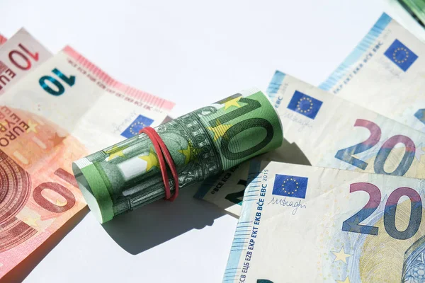 Zamykamy monetę euro. Pieniądze gotówkowe - waluta UE. Walcowane z gumowymi banknotami euro. Banknoty ułożone na siebie w różnych pozycjach — Zdjęcie stockowe