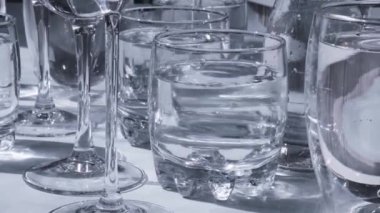 Güneş ışığında beyaz arka planda duran farklı güzel gözlükler gölgeler yaratır. Sert ışık, uzun gölgeler. Yaratıcı soyut içki konsepti, alkol kokteylleri. Cam kaplama konsepti