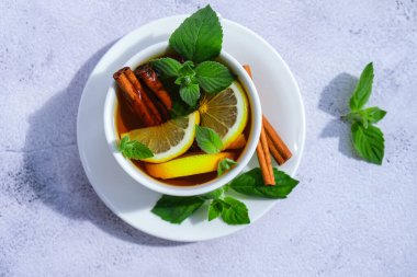Limonlu siyah ve yeşil çay, tarçınlı çubuk ve nane yaprağı. Sıcak içecek. Sağlıklı Melissa çayı fincanda doğal organik aromatik içecek. Yaz, Sonbahar Kış Isınma İçeceği. Sağlıklı bitkisel çay.