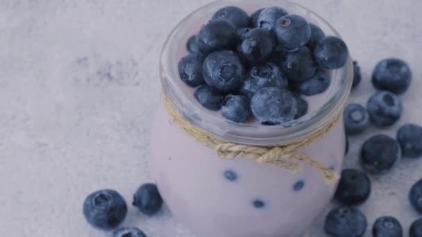 Schüssel mit Joghurt und Blaubeeren auf dem Tisch. Blaubeerjoghurt mit frischen Blaubeeren. Gesundes Frühstück. Super Food gesunde Ernährung vegetarisch vegane Nahrung