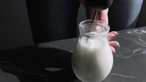 Die Milch in einem Becher mit einem Schaumaufschäumer schlagen. Handmixer für Milch vorhanden. Schaummilch mit Schaumstoff herstellen. Zubereitung von Milch für Kaffee. Schritt für Schritt — Stockvideo