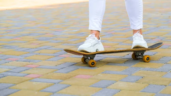 Close up Dívka skateboardista nohy skateboarding při západu slunce. sluneční podsvícení a svoboda vzbouřit nezávislý koncept. Den strávený aktivním koníčkem tabule. — Stock fotografie
