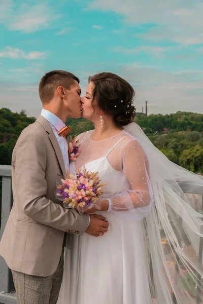 Abraço de noivo e beijo de noiva em palmeiras. Dia de casamento para dois. Um lindo casal de ervas daninhas. Jovens amantes — Fotografia de Stock