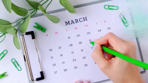 Calendario 17 de marzo. Día de San Patricio. Hoja inteligente. Colores verdes. Vacaciones de planificación de manos femeninas. Acostado. Vista superior. — Vídeos de Stock