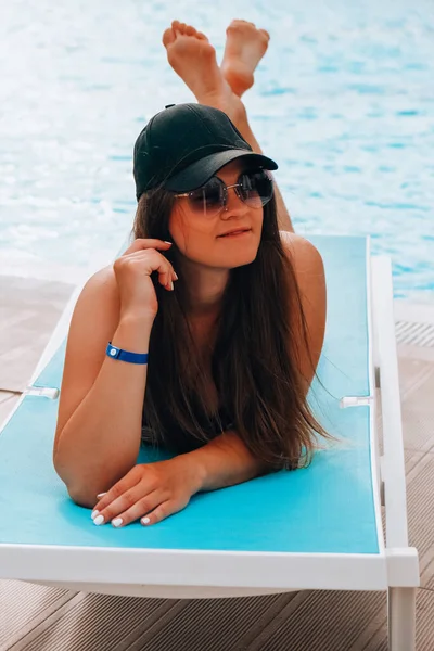 Портрет красивая молодая кавказская женщина в шляпе расслабиться улыбка досуга вокруг открытого бассейна. Летний отдых в отеле — стоковое фото