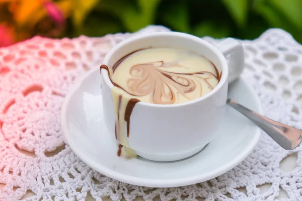 Yazın açık kafedeki masada sıcak çikolata kupası. Lokantada kahve ve kahvaltı zamanı. Çikolata, sıcak kaşlı süt, kakao. Sokak kafesi. Süt koyu çikolata.