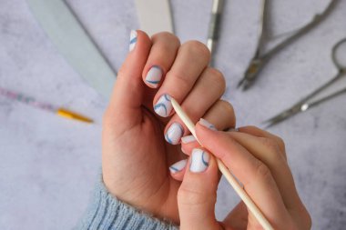 Profesyonel modaya uygun mavi hırdavat manikürü. Çivi hazırlama prosedürü. Tırnak içi temizleyicisi. Tırnak dosya makası Üst görünüm düz yatıyordu. Evde kalarak manikür yapsana. Kişisel bakım. Spa, güzellik reklamı..