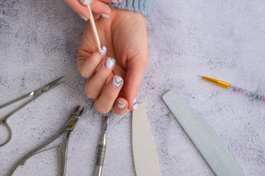 Profesyonel modaya uygun mavi hırdavat manikürü. Çivi hazırlama prosedürü. Tırnak içi temizleyicisi. Tırnak dosya makası Üst görünüm düz yatıyordu. Evde kalarak manikür yapsana. Kişisel bakım. Spa, güzellik reklamı..