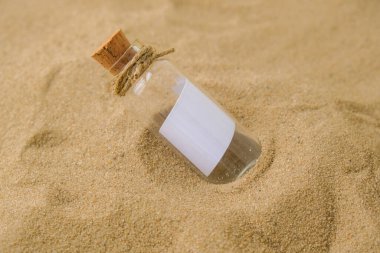Plajda şişede bir mektup. Ada yaşam tarzı. Cam bir şişede, kumdaki mantarlı kağıt bir mesaj. Kurtuluşla ilgili not, lütfen yardım et. SOS konsepti. Uzayı kopyala Model boş