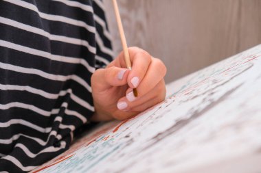 Tabloya numaralarla ve numaralandırılmış boya kavanozlarıyla resim yapmak. Kadın fırçayla tuvale numaralar çiziyor. Yaratıcı hobi. Yeni başlayanlar için resim yapmak. Evde kilitli kalmak için boş zaman aktivitesi, stres önleyici bir fikir. Meditasyon, rahatlama konsepti