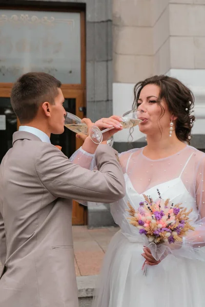 Жених и невеста держат свадебные очки с шампанским. Празднование только что поженилось. Lovely coule — стоковое фото