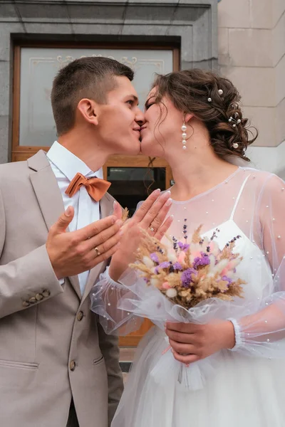 Abraço de noivo e beijo de noiva em palmeiras. Dia de casamento para dois. Um lindo casal de ervas daninhas. Jovens amantes — Fotografia de Stock