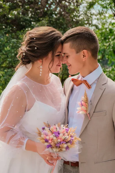 Abraço de noivo e beijo de noiva em palmeiras. Dia de casamento para dois. Um lindo casal de ervas daninhas. Jovens amantes — Fotografia de Stock