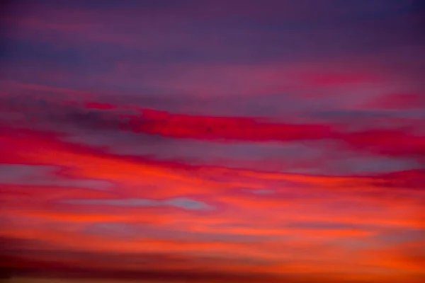 Nubes vívidas y coloridas Cielo dramático al amanecer o al atardecer. Cielo rosa rojo anaranjado con hermosas nubes en el fondo de la luz del sol. Gradiente frío para calentar al atardecer. Fondo abstracto desenfocado —  Fotos de Stock