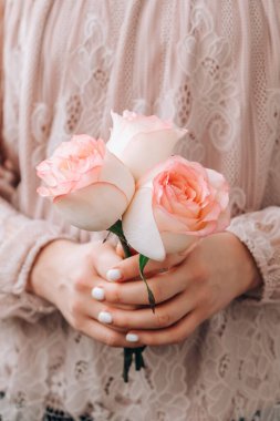 Pembe bluzlu bir kadın elinde pembe bir gül tutuyor. Minimum trend kompozisyonu. Soyut sanat fikri. Romantik pastel pembe gül çiçeği. Modern estetik. Tarafsız toprak tonları