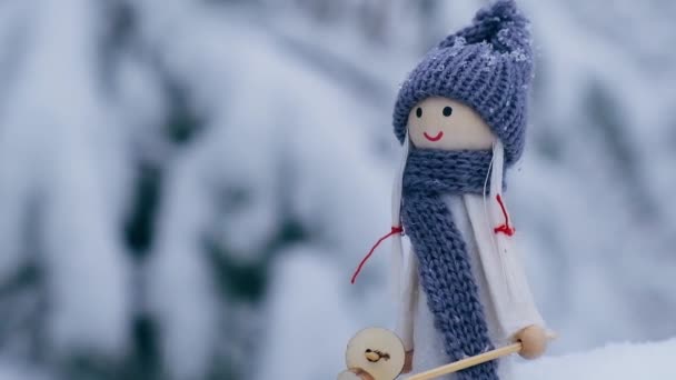 Ángel gnomo en bufanda y sombrero de punto esquiar en rama de abeto nevado Elfo juguete en esquís en el paisaje nevado Caída de nieve tiempo Nuevo año y Feliz Navidad fondo. Anuncio estación de esquí de invierno — Vídeos de Stock
