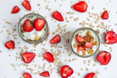 Sağlıklı kahvaltı. Yunan yoğurtlu yulaf ezmesi ve arka planda çilekli müsli. Vejetaryen, vejetaryen ve kilo verme diyeti. Detoks menüsü. Sağlıklı beslenme.