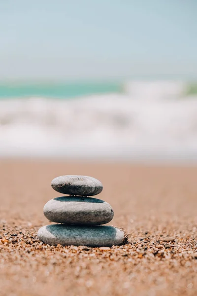 海滩上的岩石平衡 沙质海岸上的卵石金字塔 稳定的桩或堆在软焦点与Bokeh Zen Balance Minimalism Harmony Peace 海上泡沫覆盖了近岸特写 — 图库照片