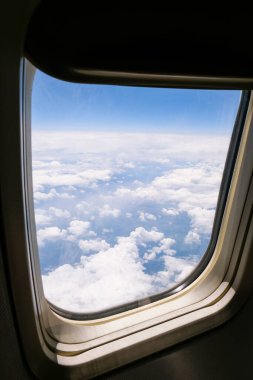Uçak uçuşu. Uçağın penceresinden bak. Uçak, uçak. Hava yoluyla seyahat etmek. Uçak Pencere Görünümü Bulutların Üzerinde İnanılmaz Altın Yumuşak bulutlar Gökyüzü üzerinde usulca hareket ediyor.