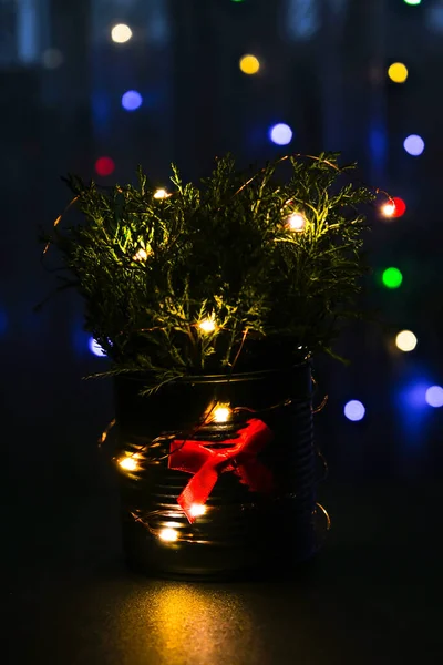 크리스마스 장식을 한 에코 리오 크리스마스 트리는 밤에 거실 배경에 불을 켜 놓은 금속 항아리 안에 있다. 낭비하지 않는 장식들. 겨울 연휴 분위기 — 스톡 사진