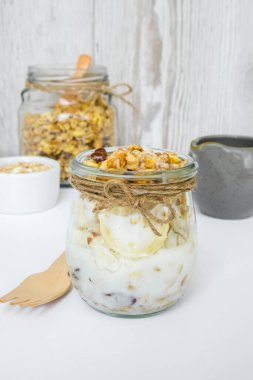 Sağlıklı kahvaltı. Yunan yoğurtlu yulaf ezmesi ve arka planda muzlu müsli. Vejetaryen, vejetaryen ve kilo verme diyeti. Detox menüsü.