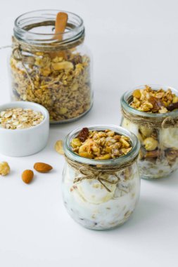 Sağlıklı kahvaltı. Yunan yoğurtlu yulaf ezmesi ve arka planda muzlu müsli. Vejetaryen, vejetaryen ve kilo verme diyeti. Detox menüsü.