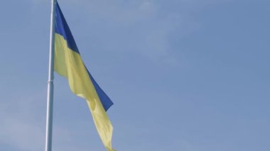 Ukrayna ulusal bayrağı mavi gökyüzüne karşı rüzgarda dalgalanıyor. Ukrayna halkının ulusal sembolü - mavi ve sarı bayrak rüzgarda dalgalanıyor.