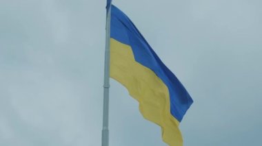 Ukrayna ulusal bayrağı mavi gökyüzüne karşı rüzgarda dalgalanıyor. Ukrayna halkının ulusal sembolü - mavi ve sarı bayrak rüzgarda dalgalanıyor.