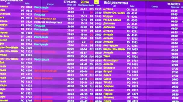 キエフ、ウクライナ6月2021忙しい空港ターミナル。新しい近代空港ターミナルへの到着と出発の飛行機の時刻表フライト情報を表示する出発ボード — ストック動画