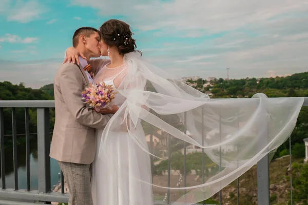 Abraço de noivo e beijo de noiva em palmeiras. Dia de casamento para dois. Um lindo casal de ervas daninhas. Jovens amantes — Fotografia de Stock