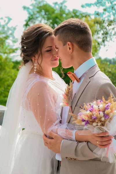 Abraço de noivo e beijo de noiva em palmeiras. Dia de casamento para dois. Um lindo casal de ervas daninhas. Jovens amantes — Fotografia de Stock