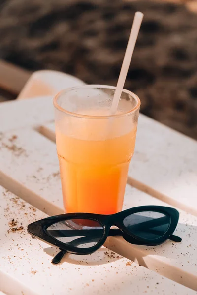 Frischer kalter Mango-Smoothie-Cocktail auf tropischem Sand. Sommerurlaub am Meer und Reisekonzept. Glas Fruchtcocktail und Sonnenbrille. — Stockfoto