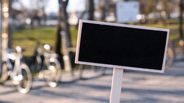 Töm mockup mall Blackboard etikett mot defocused bakgrund av cykeldelning station. Cyklar på cykel parkering. Annons Eco Transport Concept Cykel (att hyra) Miljövänliga lägen — Stockfoto