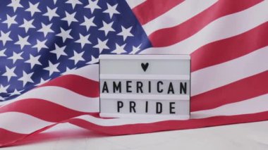 Ağır çekim dalgalanan Amerikan Bayrağı Arkaplanı. Amerika Birleşik Devletleri 'nin Amerikan Gururlu Bayrağı yazılı ışık kutusu. 4 Temmuz Bağımsızlık Günü. Amerikan vatanseverliği ulusal bayramı. Usa gurur duyuyor.
