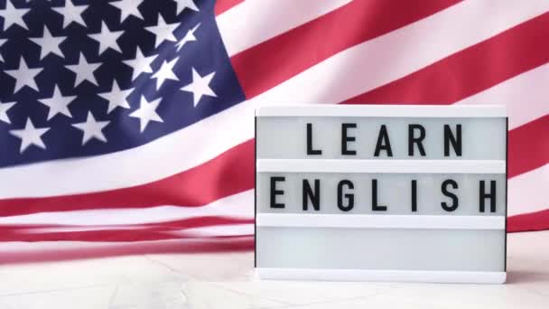 4k Waving American Flag Hintergrund. Leuchtkasten mit Text LEARN ENGLISH Flag der Vereinigten Staaten von Amerika. 4. Juli, Unabhängigkeitstag. Nationalfeiertag des Patriotismus in den USA. USA stolz. — Stockvideo