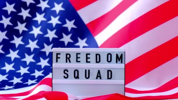 4k κυματίζει αμερικανική σημαία φόντο. Lightbox με κείμενο FREEDOM SQUAD Σημαία των Ηνωμένων Πολιτειών της Αμερικής. 4η Ιουλίου Ημέρα Ανεξαρτησίας. ΗΠΑ πατριωτισμός εθνική εορτή. Ο Ούσα περήφανος. — Αρχείο Βίντεο