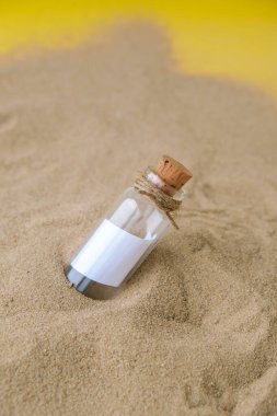 Plajda şişede bir mektup. Ada yaşam tarzı. Cam bir şişede, kumdaki mantarlı kağıt bir mesaj. Kurtuluşla ilgili not, lütfen yardım et. SOS konsepti. Uzayı kopyala Model boş