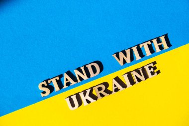 Kağıttan yapılmış Ukrayna ulusal bayrağı. Ukraine metni ile ayakta dur. Savaşı durdurun. Ukrayna 'daki savaşı bitirme kavramı. Ukrayna halkının ulusal sembolü - mavi ve sarı. Rus işgaline karşı savaş protestosu. pankart boyutu