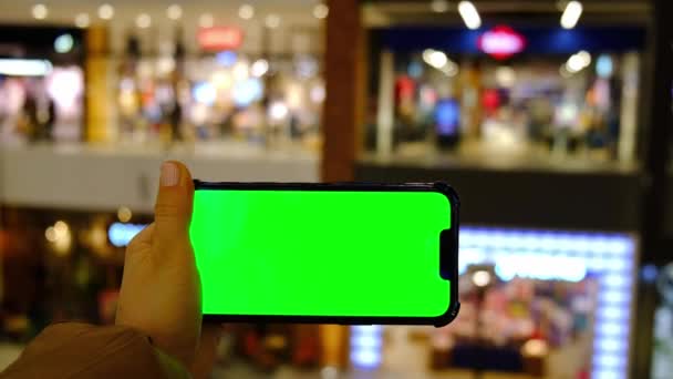Chave Chroma 4k. Close up de mão mulher detém telefone inteligente com tela verde na loja shopping. Centro comercial. Loja de departamentos. Compras online. Modelo de dispositivos — Vídeo de Stock
