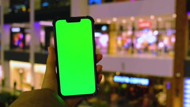 4k Chroma key. Close up of woman hand holds smart phone with green screen at shopping mall store. Shopping center. Department store. Shopping online. Gadgets template — Stock Video