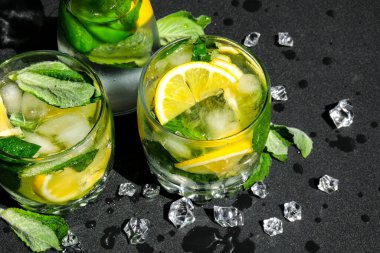Mojito ferahlatıcı kokteyl, alkol içeceği. Limonlu limonata ve arka planda nane yaprağı. Buz küpleri. Yaz ferahlatıcı detoks içecekleri. Temiz yemek, sağlıklı yaşam tarzı konsepti, diyet. Beslenme