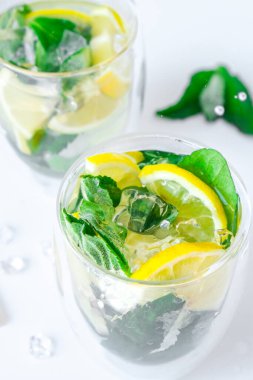 Mojito ferahlatıcı kokteyl, alkol içeceği. Limonlu limonata ve arka planda nane yaprağı. Buz küpü sıçrama damlası. Yaz ferahlatıcı detoks içecekleri. Temiz yemek, sağlıklı yaşam tarzı konsepti, diyet. Beslenme.