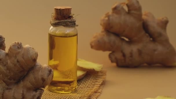 玻璃瓶中的生姜精油,生姜根呈米黄色背景.健康饮食的概念。薄荷油香精油.护肤、护体和护发的天然化妆品成分 — 图库视频影像
