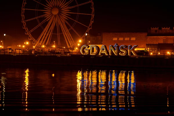 2022 년 3 월 폴란드 그단스크 (Gdansk Poland) 에서 밤에 구 도시 그단스크 (Gdansk) 의 페리스 휠 (Ferris wheel) 이 그단스크 (Gdansk Poland Europe) 에서 우크라이나 국기의 파란색 과 노란색을 반사한다. 우크라 이나를 지원하고 지원하다 — 스톡 사진