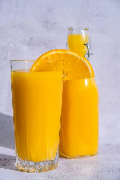 Стеклянная Бутылка Свежевыжатого Апельсинового Сока Нарезанными Фруктами Бетонном Фоне Фруктовый — стоковое фото