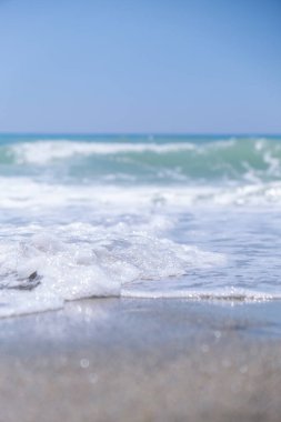 Okyanus dalgaları kumsalı yıkar. Seyahat yaz konsepti. Plajda tatil. Akdeniz 'in dalgaları kumlu plaja doğru gün ışığında akıyor. Yaz tatili