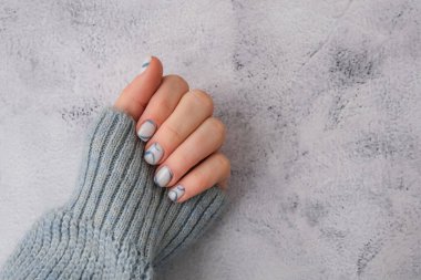 Modaya uygun mavi kadın tırnakları. Modern moda stil güzel manikür. Sonbahar kış tırnağı, güzellik tedavisinin minimalist tasarım konsepti. Jel tırnaklar. Cilt bakımı. Uzayı metin için kopyala. Güzellik reklamı. Sağlıklılık. Moda renkleri.