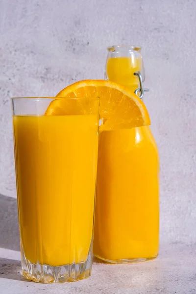 玻璃瓶新鲜挤压橙汁与切片水果在混凝土背景 新鲜的冷饮 夏天再来一次 水果切成两半 复制空间 — 图库照片