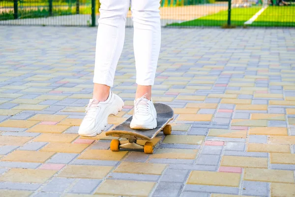 Close up Dívka skateboardista nohy skateboarding při západu slunce. sluneční podsvícení a svoboda vzbouřit nezávislý koncept. Den strávený aktivním koníčkem tabule. — Stock fotografie